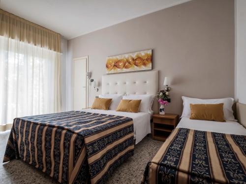 sypialnia z 2 łóżkami i oknem w obiekcie Hotel Bridge w Rimini