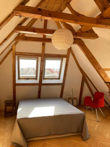 1 dormitorio con 1 cama y 1 silla roja en Apartament Piwna, en Gdansk