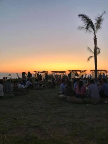 a group of people sitting around watching the sunset at La dimora di Clara in Trapani