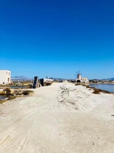 a sandy beach with a body of water at La dimora di Clara in Trapani