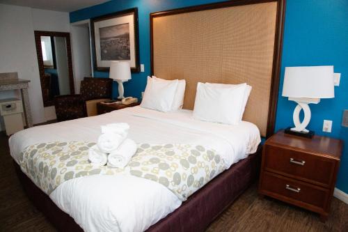 a hotel room with a bed with a teddy bear on it at Daytona Dream Inn By AmeriVu in Daytona Beach