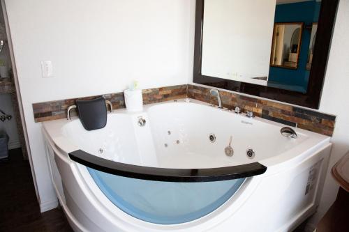a bath tub in a bathroom with a mirror at Daytona Dream Inn By AmeriVu in Daytona Beach