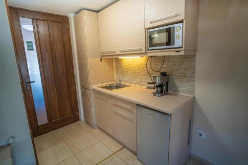 a small kitchen with a sink and a microwave at 4 ÁSZ Deluxe Apartman in Gyula