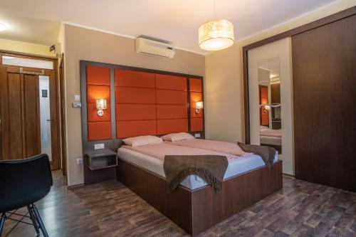 a bedroom with a large bed and a mirror at 4 ÁSZ Deluxe Apartman in Gyula