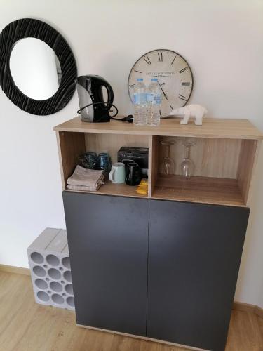une étagère avec une horloge et un miroir dans l'établissement Villa des Roses - Appart T2, 31m2, 1er étage, vue jardin, 
