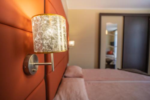 a bedroom with a bed and a door with a lamp at 4 ÁSZ Deluxe Apartman in Gyula
