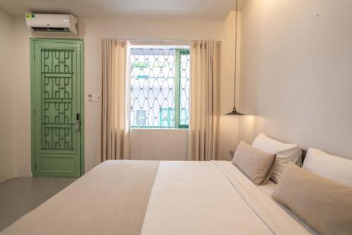 a bedroom with a bed and a window at La Memoria Hotel - City Centre in Ho Chi Minh City