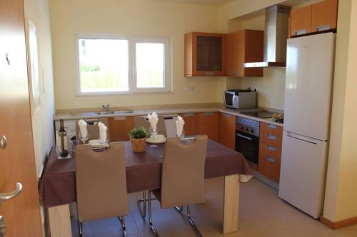 y cocina con mesa, sillas y nevera. en BURGUNA Apartment, 500m from Burgau Beach, en Burgau
