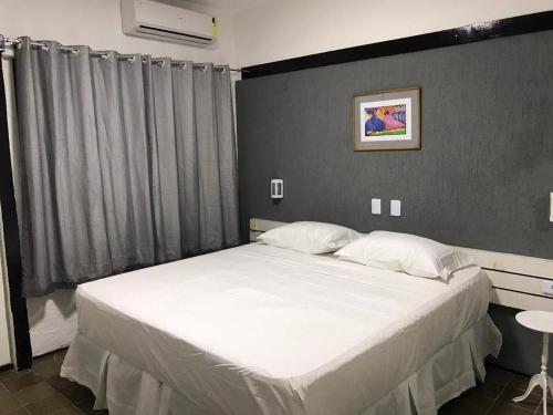 um quarto com uma cama grande e lençóis brancos em 501 Lindo Flat mobiliado com VISTA TOTAL MAR na Praia de Iracema em Fortaleza