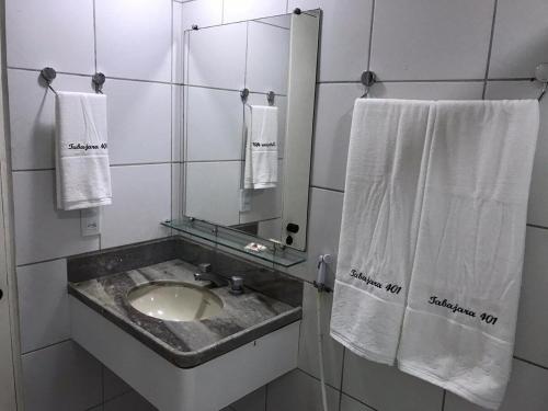 ein Badezimmer mit einem Waschbecken, einem Spiegel und Handtüchern in der Unterkunft 501 Lindo Flat mobiliado com VISTA TOTAL MAR na Praia de Iracema in Fortaleza