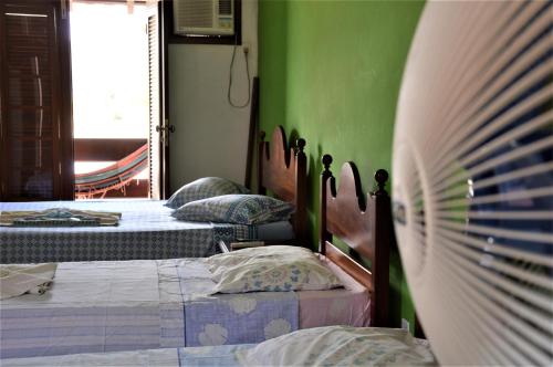 a bedroom with two beds and a green wall at Pousada do Imperador in Paraty