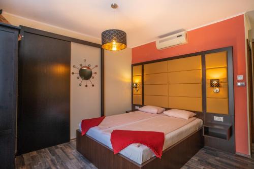 a bedroom with a bed with a red head board at 4 ÁSZ Deluxe Apartman in Gyula