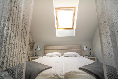 a small bedroom with a bed with a window at 4 ÁSZ Deluxe Apartman in Gyula