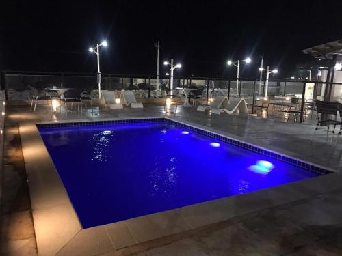 a blue swimming pool on a roof at night at 507 Lindo Flat mobiliado na Praia de Iracema in Fortaleza