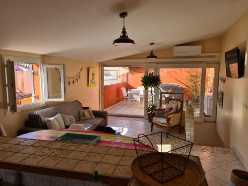 un salon avec un canapé et une table dans l'établissement La tropezienne, Duplex 73 m2, 100 m du port, climatisation, grande terrasse, à Sanary-sur-Mer