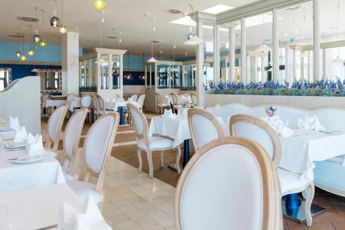 a restaurant with white tables and chairs at Royal Obidos Scenic Resort in Casal da Lagoa Seca