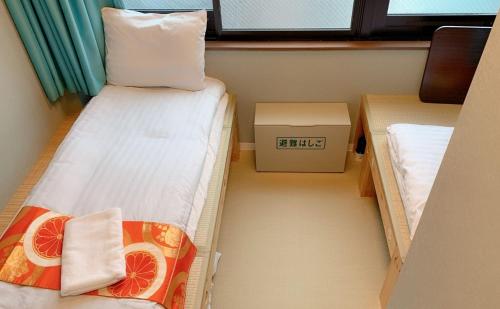 ein kleines Zimmer mit 2 Betten und einem Fenster in der Unterkunft Jing House akihabara Ryokan - Vacation STAY 30899v in Tokio