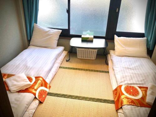 2 camas individuais num quarto com uma janela em Jing House akihabara Ryokan - Vacation STAY 11566v em Tóquio