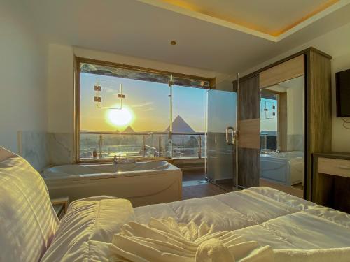 Schlafzimmer mit einem Bett, einer Badewanne und einem Fenster in der Unterkunft Best View Pyramids Hotel in Kairo