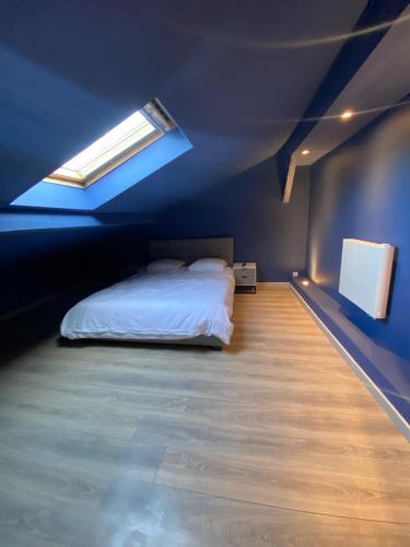 a blue bedroom with a bed and a window at Capstay Cosy centre 2 chambres babyfoot & Netflix in Raismes