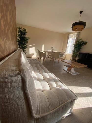 a large couch in a living room with a table at Capstay Cosy centre 2 chambres babyfoot & Netflix in Raismes
