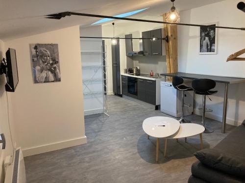 a kitchen and a living room with a table and chairs at Le celebrity in Agen