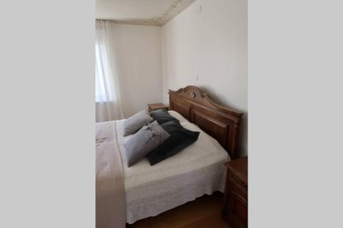 1 cama con cabecero de madera en una habitación en Boende i uppgränna med panoramautsikt en Gränna