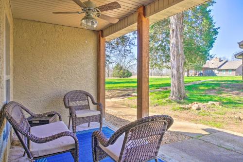 a porch with wicker chairs and a ceiling fan at The Cozy Cottage with Lake Taneycomo Access! in Branson