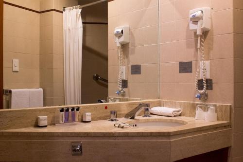 a bathroom with a sink, mirror and bath tub at Hotel Marlowe Centro Histórico in Mexico City