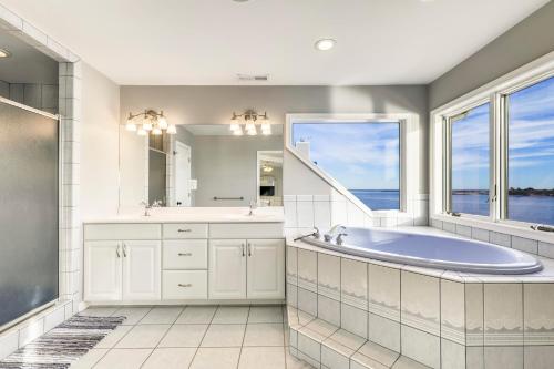 een badkamer met een bad en een groot raam bij Sunset Getaway in Ocean City