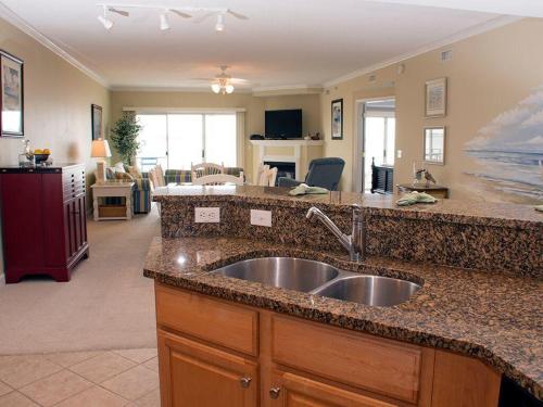 a kitchen with a sink and a living room at Bahia Vista I in Ocean City