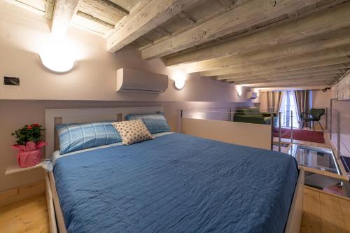 a bedroom with a blue bed in a room at BRIXIA LUXORY & LOFT in Brescia