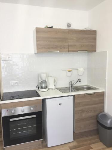 une petite cuisine avec un évier et une cuisinière dans l'établissement Studio à 2 pas de la promenade des anglais, à Nice