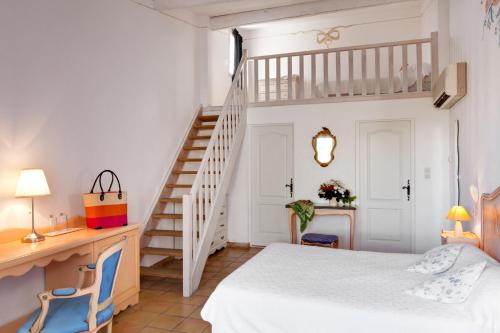 a bedroom with a white bed and a staircase at Hotel La Tramontane in Saintes-Maries-de-la-Mer