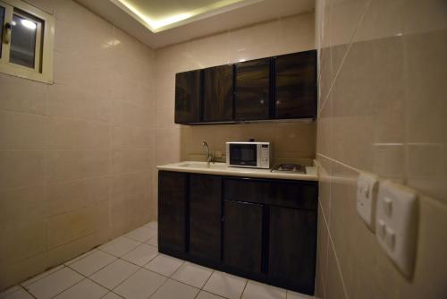 a small kitchen with a sink and a microwave at شقق روعه المصايف للشقق المخدومه in Taif
