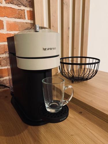 a coffee maker with a glass on a table at Maison en pierres au calme près d'Ancenis in Mésanger