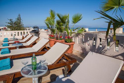 a row of chairs and tables on a rooftop patio at Manolia Dream Apartment 3-bedrooms 30m to the beach in Agia Marina Nea Kydonias