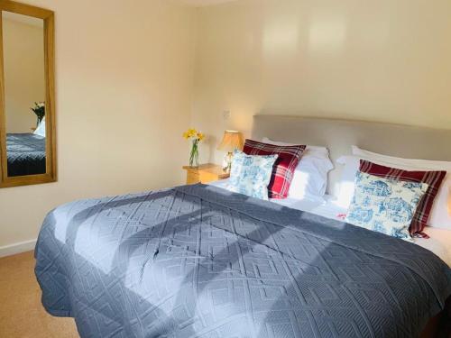 a bedroom with a large bed and a mirror at George & Dragon Country Pub & Hotel Wolverton Townsend in Tadley