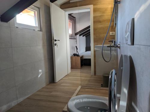 uma casa de banho com um WC e uma cabina de duche ao nível do chão em L'Hotel em Prizren