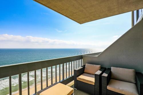 a balcony with two chairs and the ocean at Century 2 in Ocean City