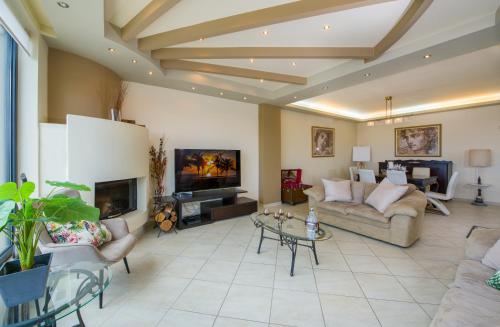 a large living room with a couch and a fireplace at Manolia Dream Apartment 3-bedrooms 30m to the beach in Agia Marina Nea Kydonias