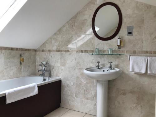a bathroom with a sink and a tub and a mirror at Victoria inn in Durham