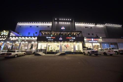 a building with cars parked in a parking lot at night at شقق روعه المصايف للشقق المخدومه in Taif