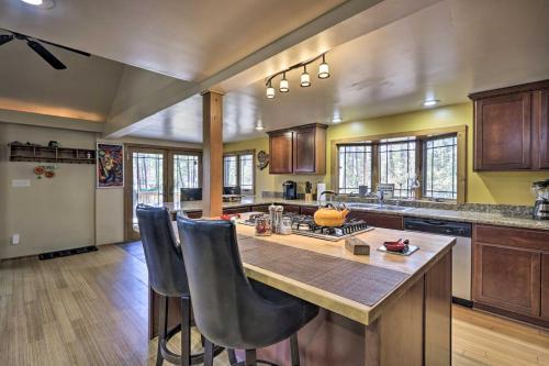 a large kitchen with a large island with bar chairs at Near Tonto National Forest Dog-Friendly Cabin! in Payson