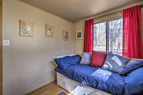 a room with a couch and a window with red curtains at Near Tonto National Forest Dog-Friendly Cabin! in Payson