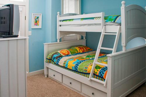 a bedroom with two bunk beds with a ladder at Sunset Island - 3 Canal Side Mews in Ocean City