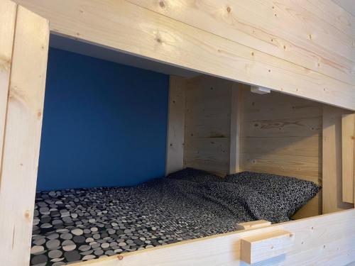 drewniane łóżko piętrowe z niebieską ścianą w obiekcie Les pieds dans l eau w mieście Erpion