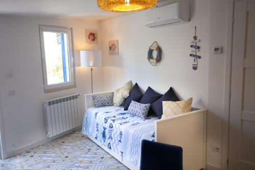 Un dormitorio con una cama con almohadas azules y una ventana en DilettaAnna Luxury apartment en Tropea