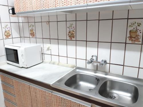 a kitchen with a sink and a microwave at Cortijo Aire del desierto rústico y tranquilo entre el mar y desierto - Alborania in Pechina