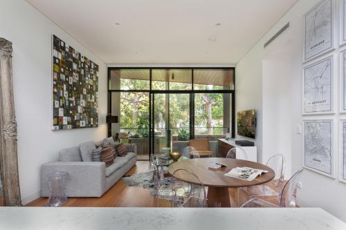 a living room with a table and a couch at Stylish 2-Bed Apartment with BBQ Patio Near Beach in Sydney